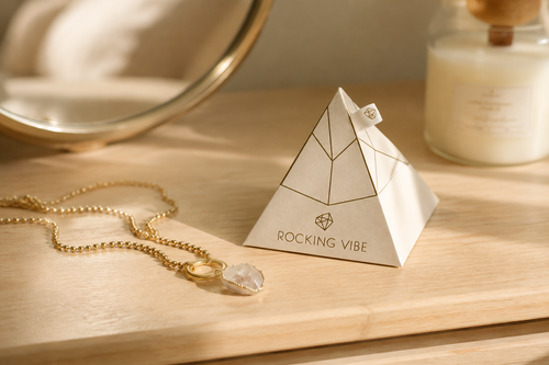 Rocking Vibe Intention Pyramid displayed on a shelf with a necklace and candle