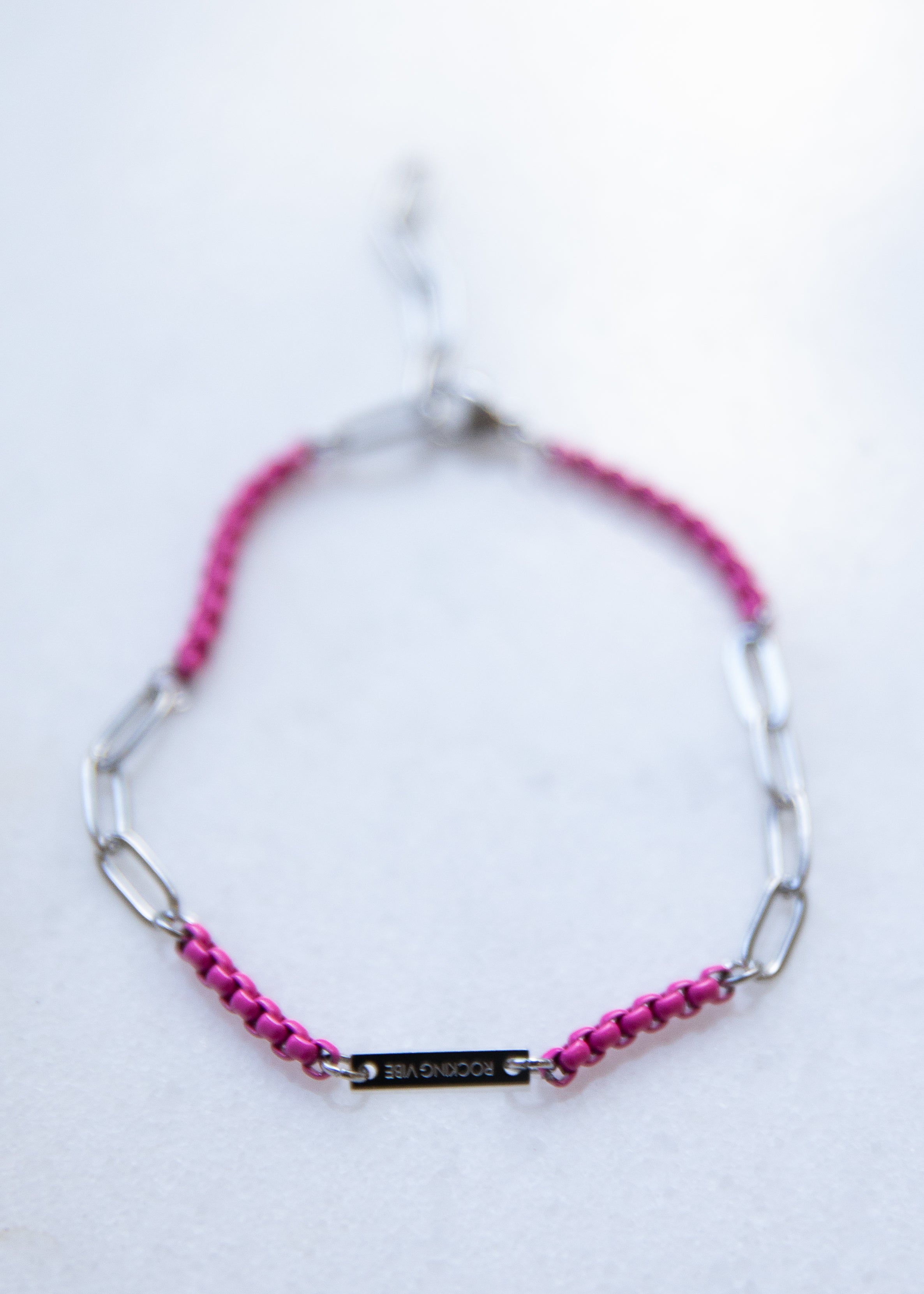 Bracelet with pink and a silver chain on a white background